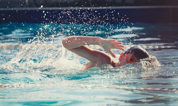 boy in swimming pool doing front crawl 