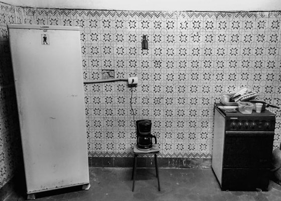 Fridge, kettle and old cooker in a run down and dirty kitchen