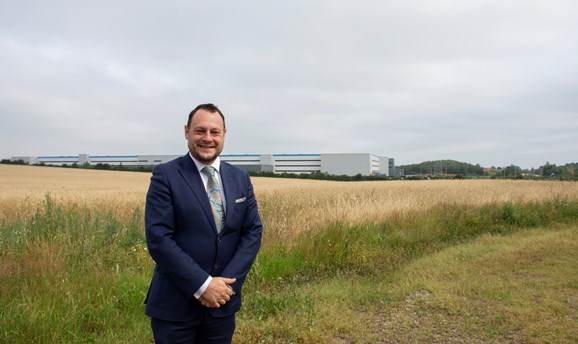 Jason Zadrozny standing in front of the Amazon fulfilment centre