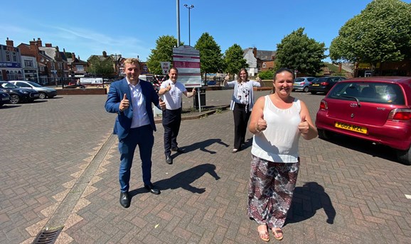 Councillors standing in a car park with thumbs up