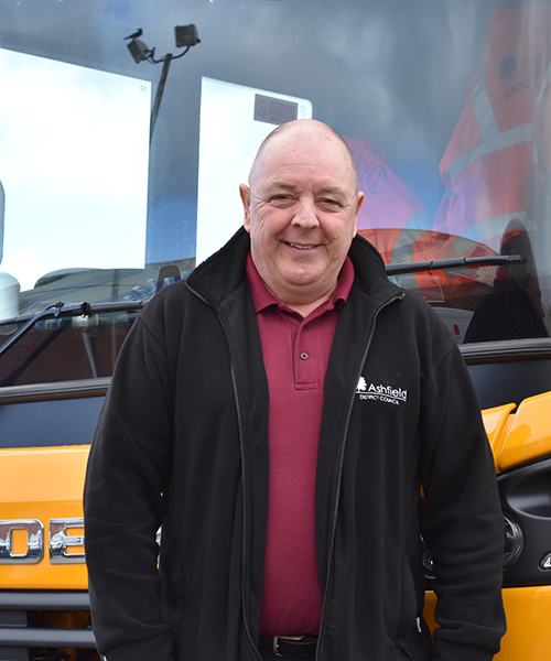 Smiling man in ADC logo fleece standing in front of works vehicle