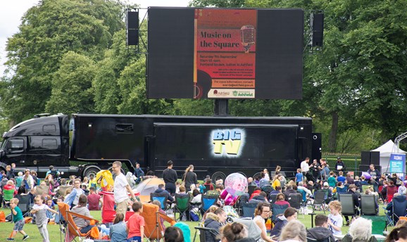 crowds sat on chairs on Sutton Lawn in front of a big cinema screen 